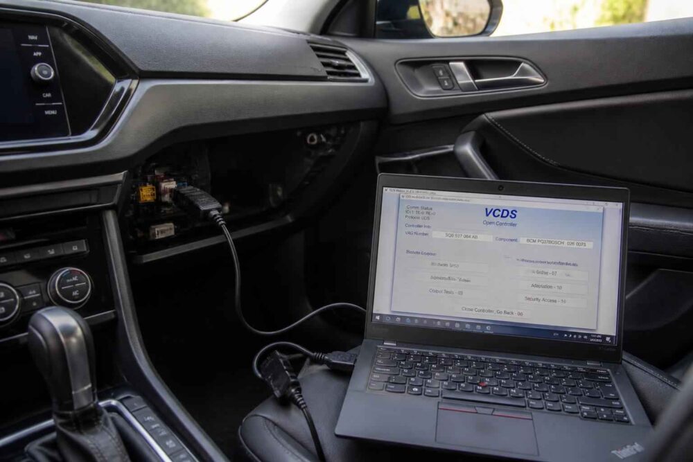 Laptop z programem VCDS podłączony do gniazda diagnostycznego auta kozultant