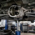 Otwarty tylny mechanizm różnicowy samochodu podczas naprawy na podnośniku warsztatowym