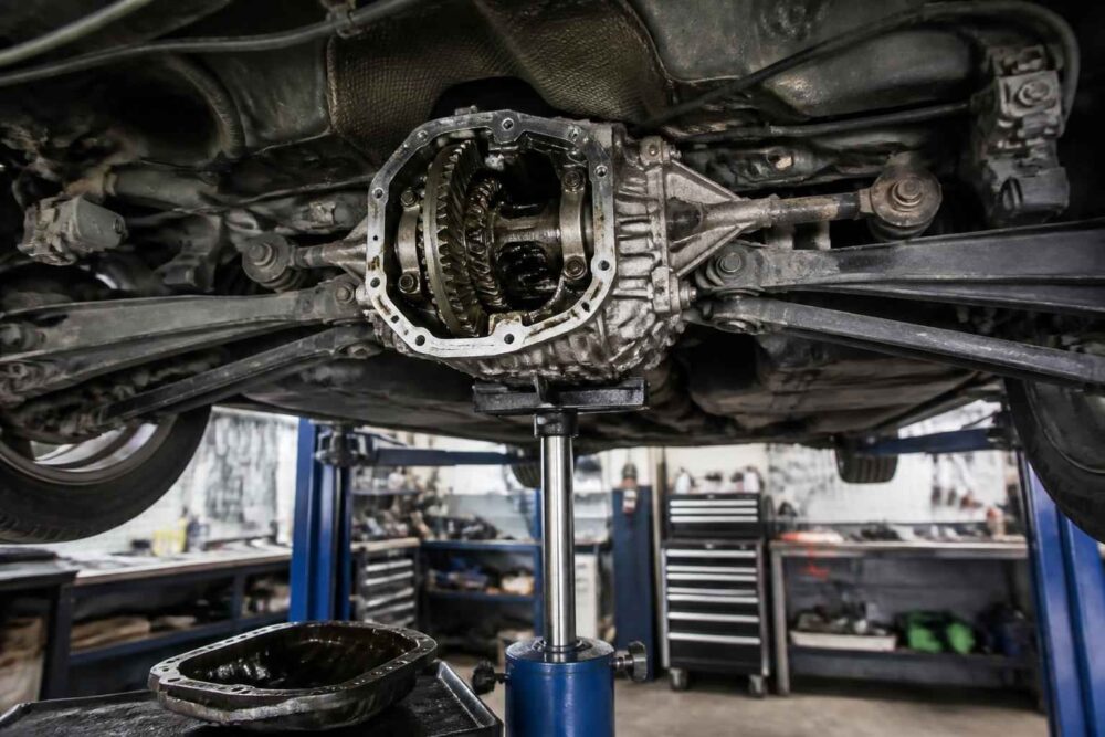 Otwarty tylny mechanizm różnicowy samochodu podczas naprawy na podnośniku warsztatowym