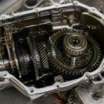 Otwarta skrzynia biegów z widocznymi kołami zębatymi i mechanizmem przekładniowym